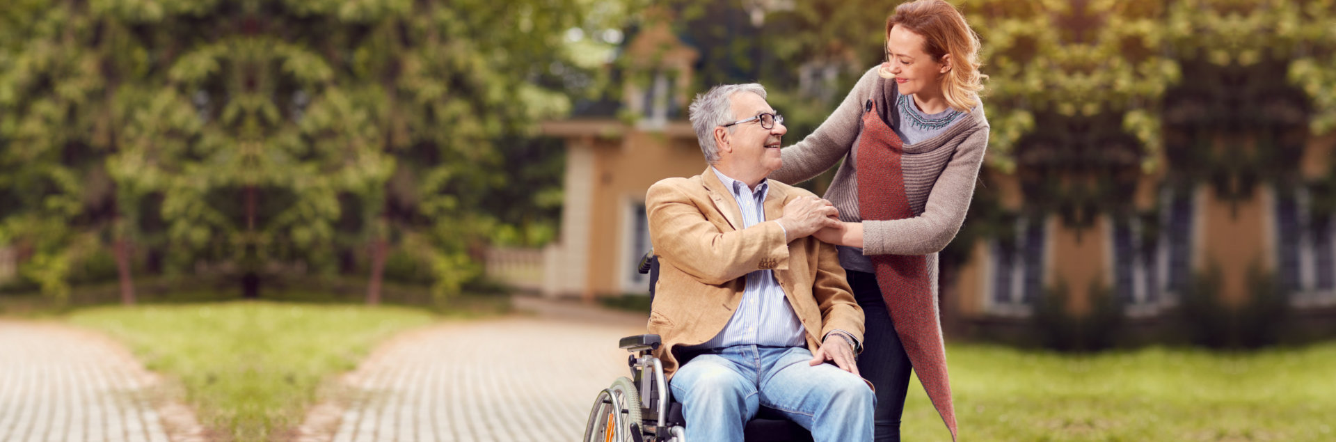 Elderly men in wheelchair with her cheerful caregiver