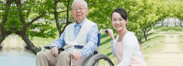 caregiver and patient in a wheelchair smiling