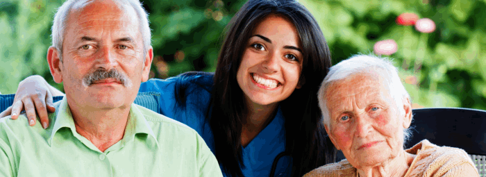 caregiver hugging two elderly patient